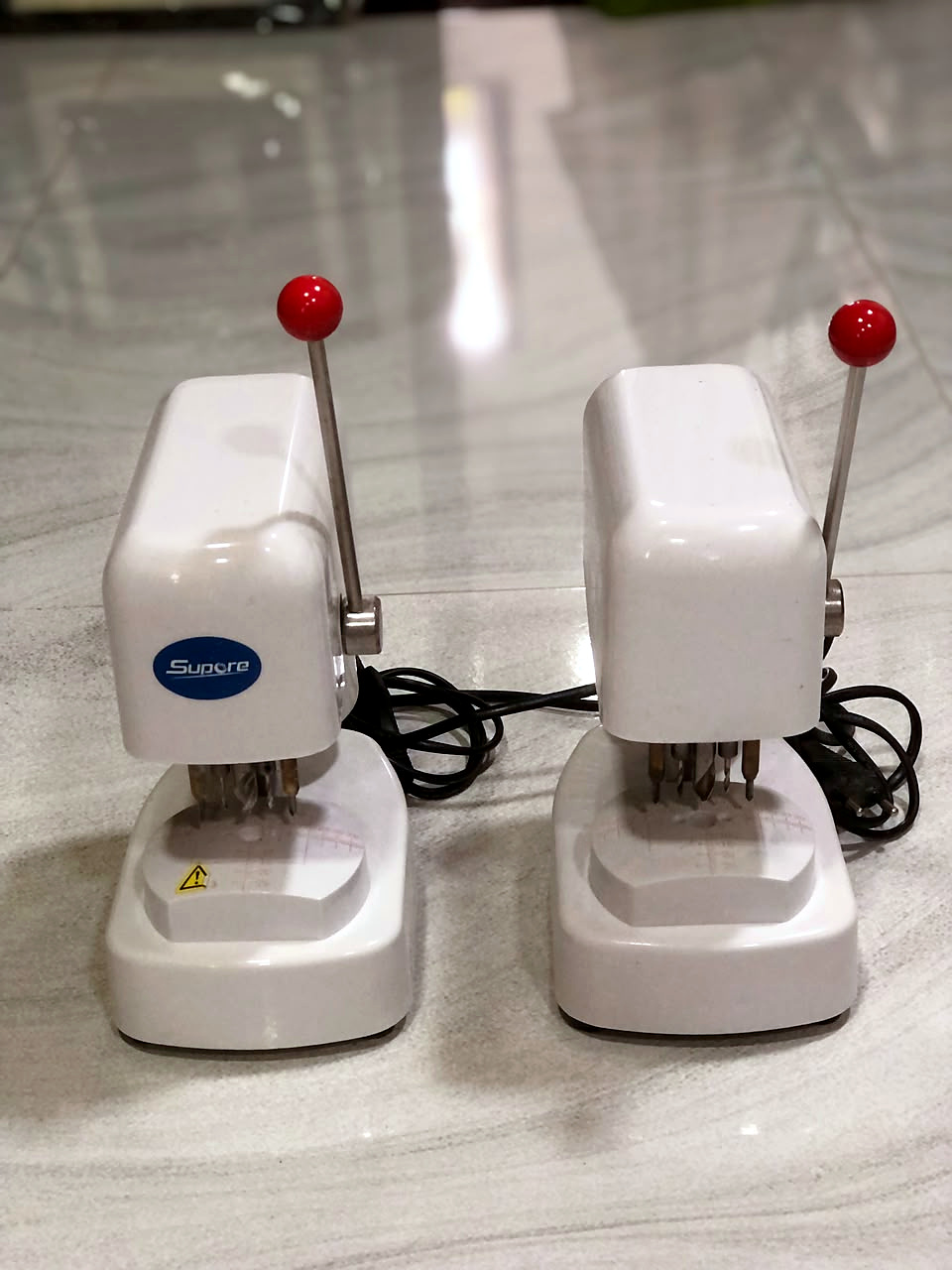 Two lens drilling units with red-handled levers